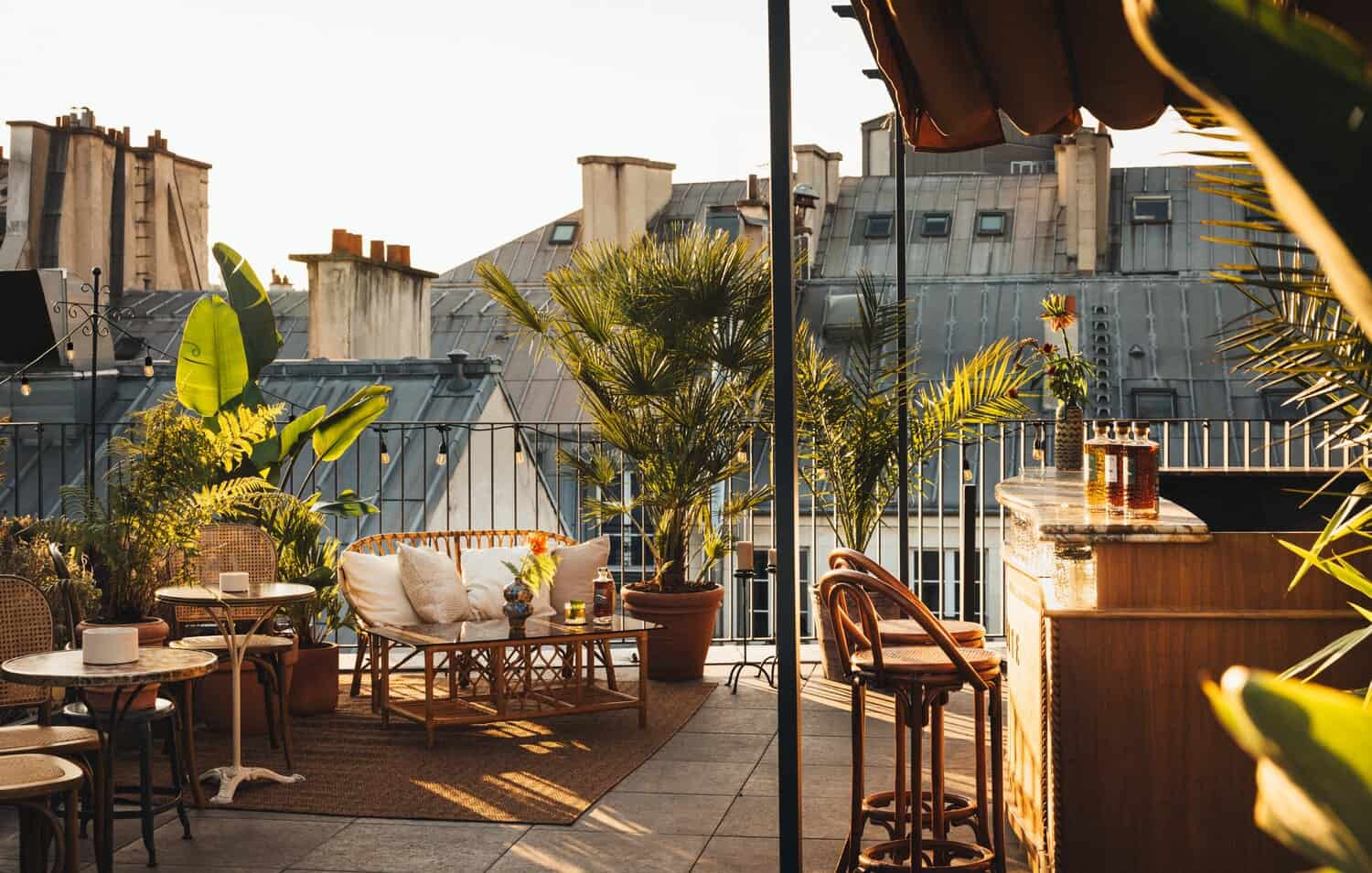 El rooftop con sofás y mesas, rodeado de plantas y vistas a los tejados parisinos. 